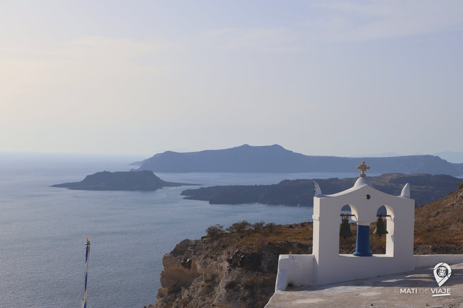 Campanario blanco frente a la caldera de Santorini